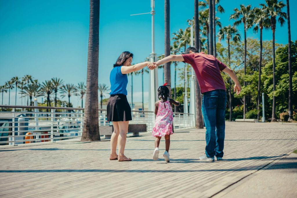 A joyful family enjoying a walk outdoors under sunny skies, fostering togetherness.