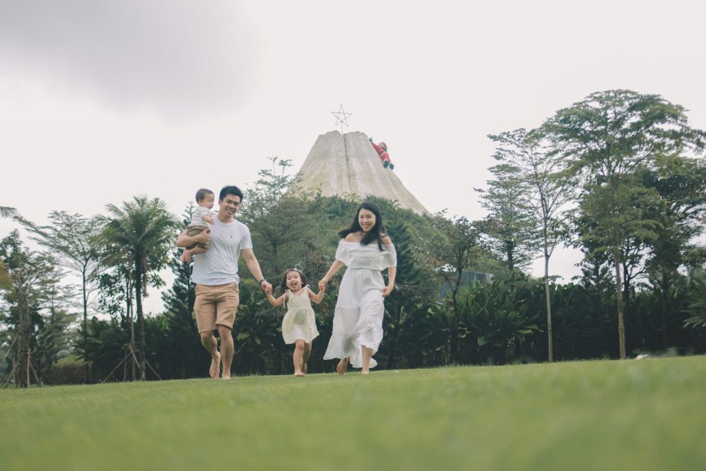 Family walking on grass with volcano background